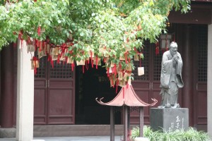 Une statue de Confucius et, à l'avant-plan, un arbre à souhaits...